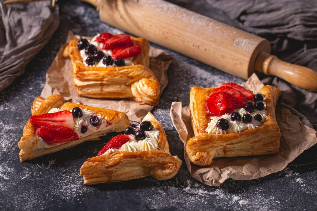 vier Gebäckstücke mit Erdbeeren und Blaubeeren darauf